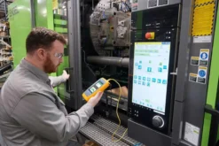 Fluke LinkIQ industrial tester being used to test M12 connector cable on factory floor