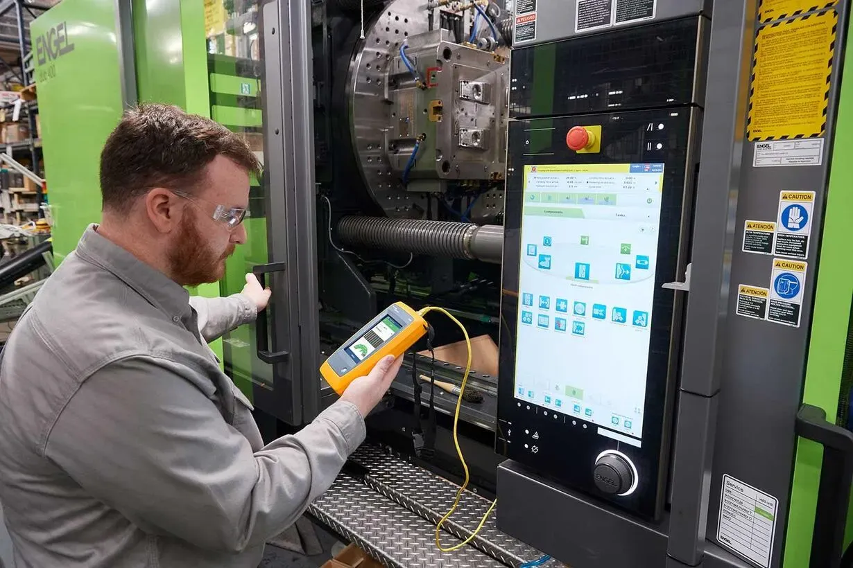 Fluke LinkIQ industrial tester being used to test M12 connector cable on factory floor